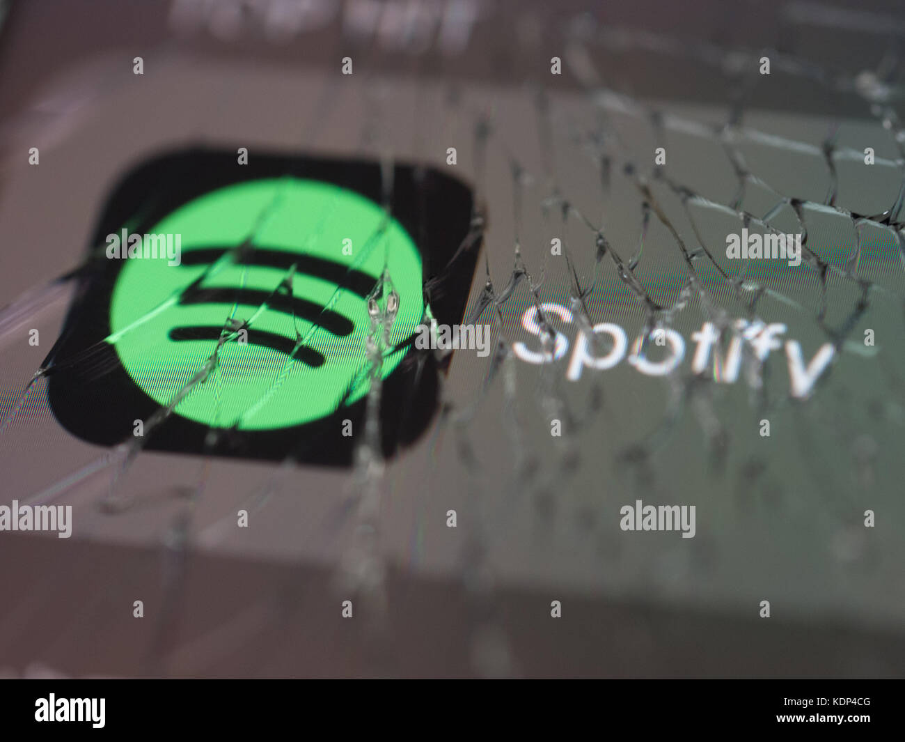 Das Spotify-Logo wird auf einem defekten Smartphone-Bildschirm angezeigt Stockfoto
