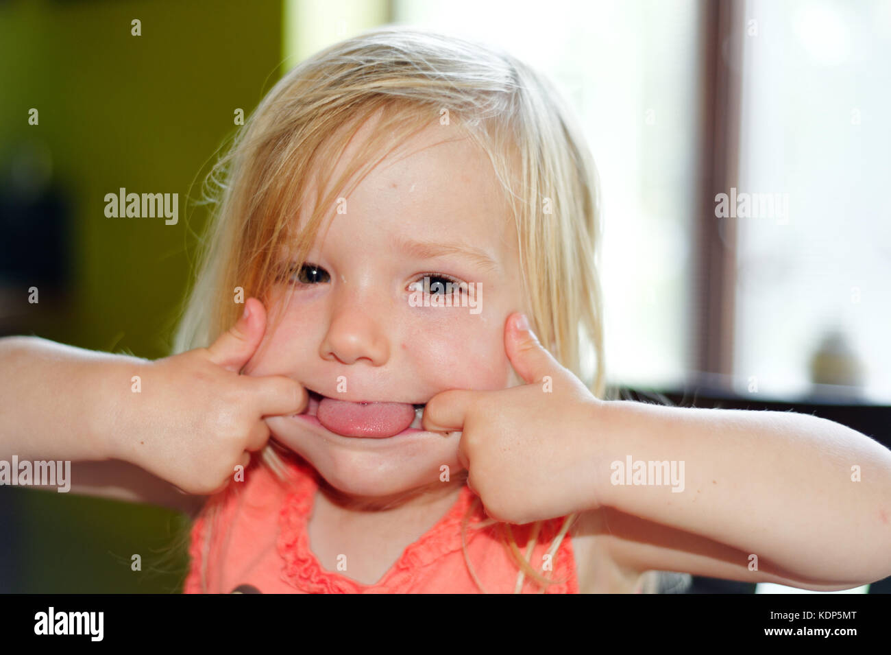 Ein drei Jahre altes Mädchen Gesichter ziehen Stockfoto
