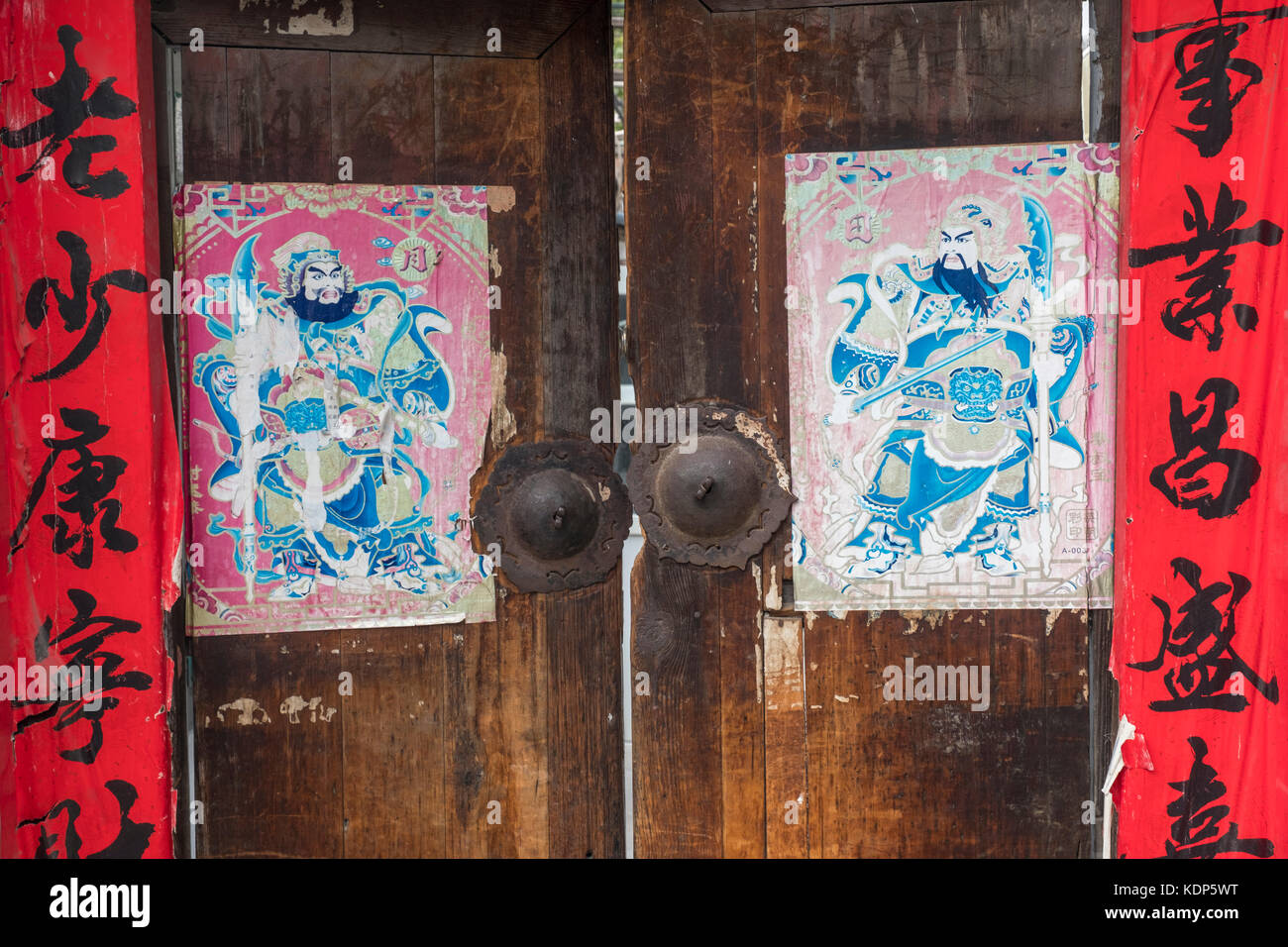 Eine alte Tür mit Frühlingsfest couplets, Chinesisch Tür-Keepers und rostige Klopfer, in einer Hutong in Peking, China. Stockfoto