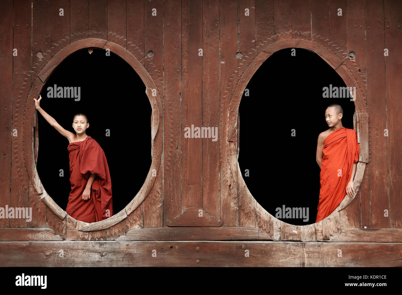 Myanmar, junge novizin Buddhistische Mönche in Roben in Holz ovale Fenster Shwe Yaunghwe Kyaung Kloster in Nyaungshwe in der Nähe Inle See gekleidet Stockfoto