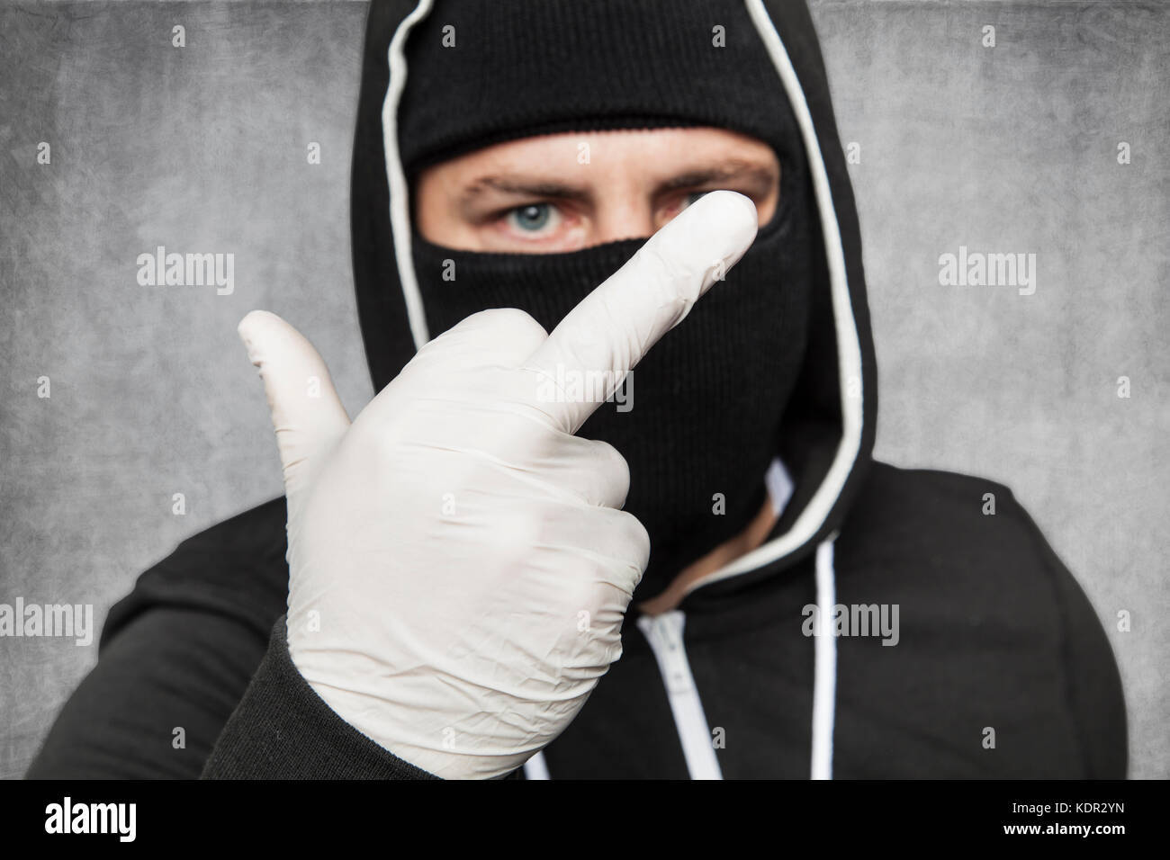 Maskierte Mann zeigt Mittelfinger Stockfoto