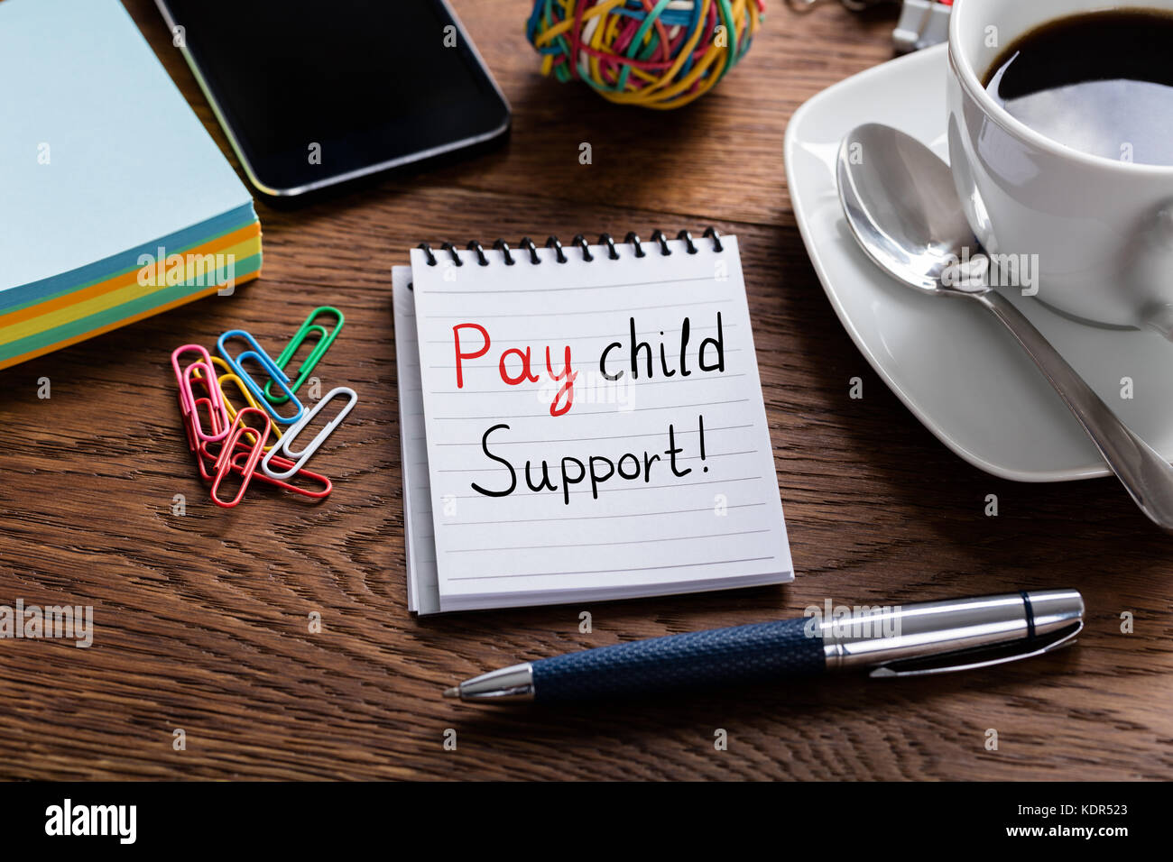 Hohe Betrachtungswinkel von Pay Kindergeld Konzept auf Notepad bei hölzernen Schreibtisch geschrieben Stockfoto
