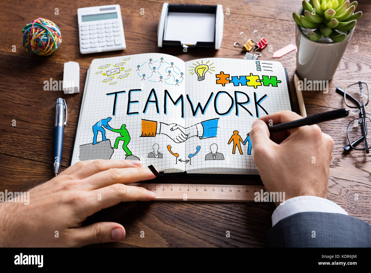 Nahaufnahme der Unternehmer Zeichnung Teamarbeit Konzept auf Notebook am Schreibtisch aus Holz Stockfoto
