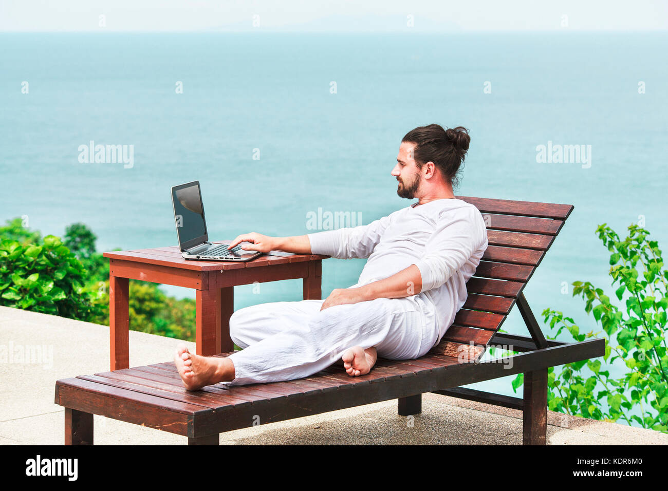 Unternehmer tragen weiße mit Laptop am Strand Stockfoto