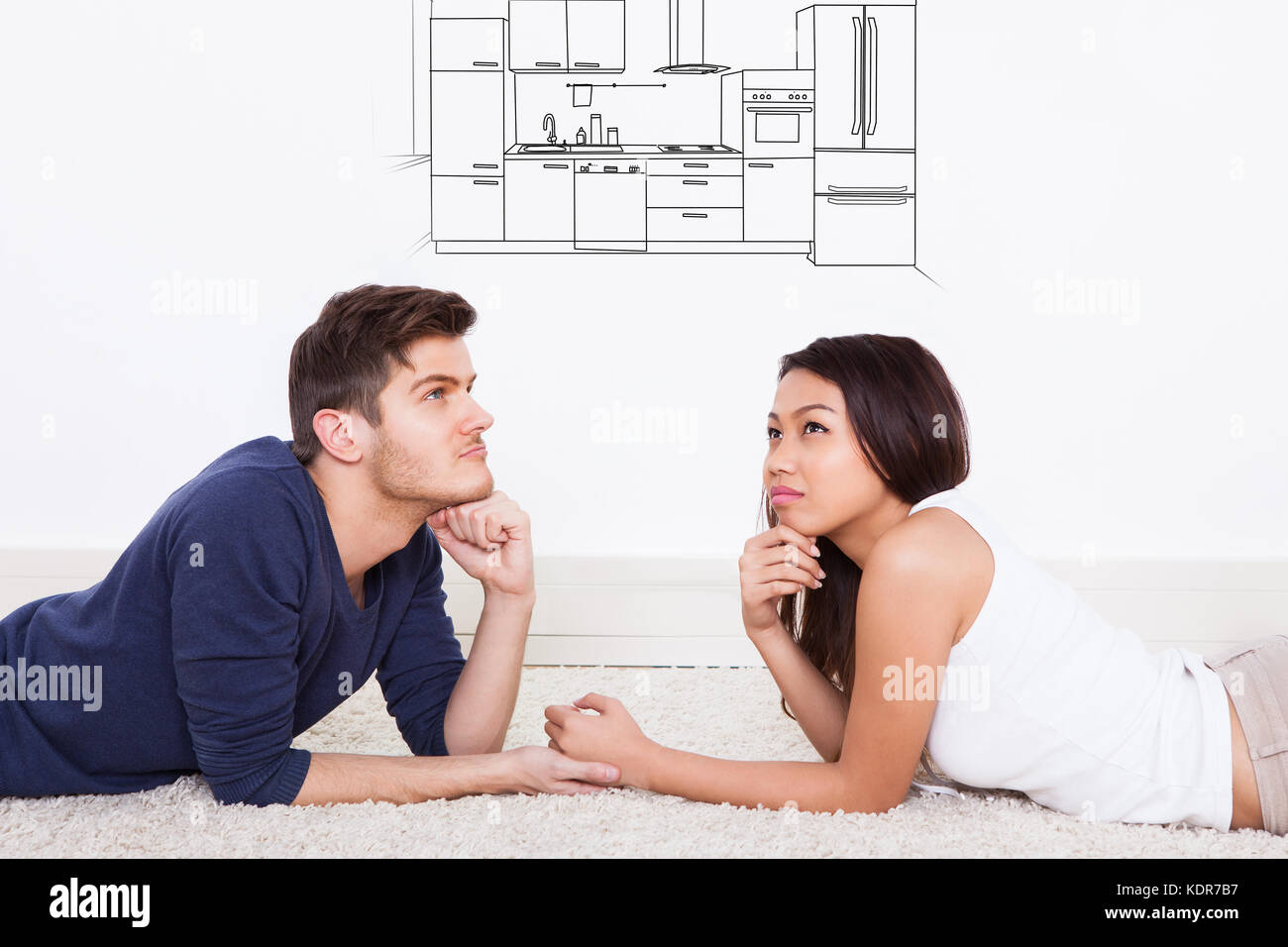 Junges Paar auf dem Teppich liegend Denken, moderne Küche in Ihrem Haus Stockfoto