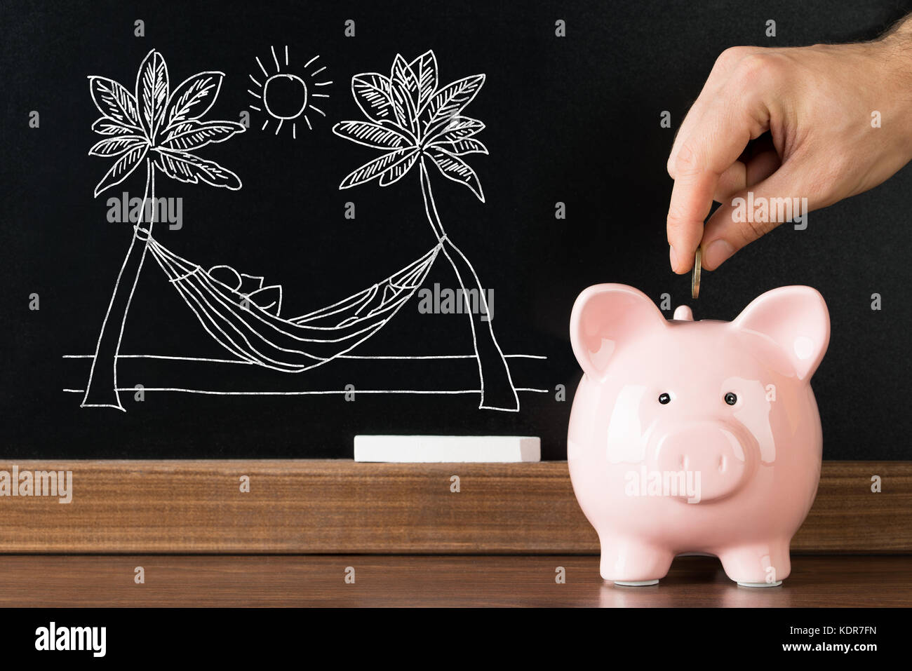 Nahaufnahme der Person Hand sparen Geld im Sparschwein für den Urlaub am Strand. Stockfoto