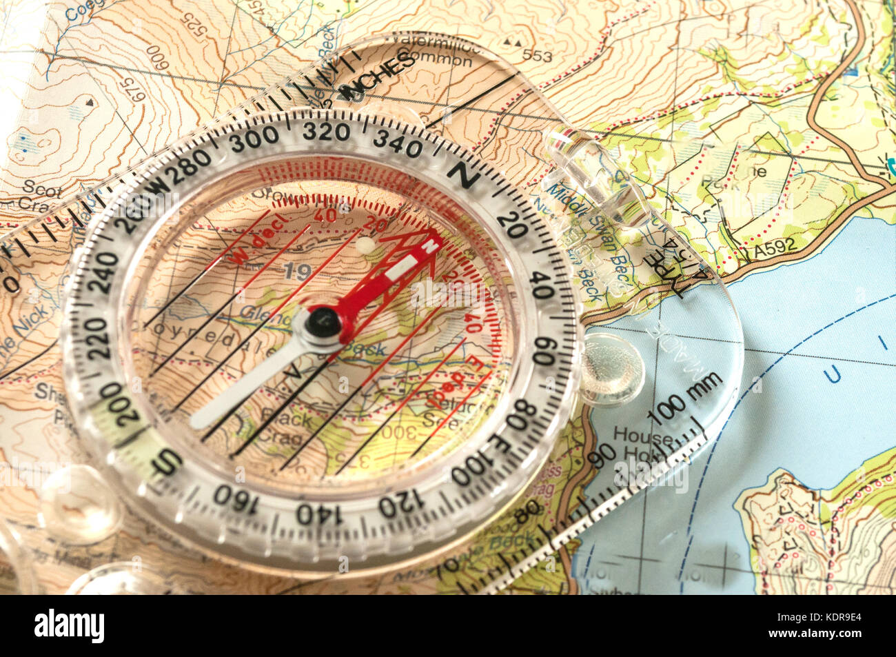 Kompass zeigt Richtung auf topografischer Karte, mit Rettungspfeife, geringe Schärfentiefe Stockfoto