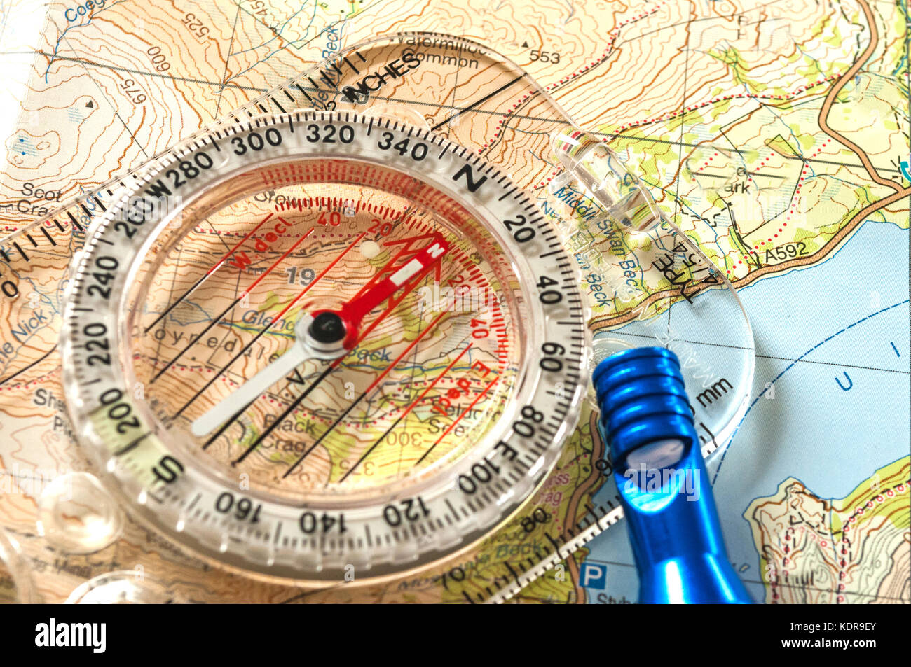 Kompass zeigt Richtung auf topografischer Karte, mit Rettungspfeife, geringe Schärfentiefe Stockfoto