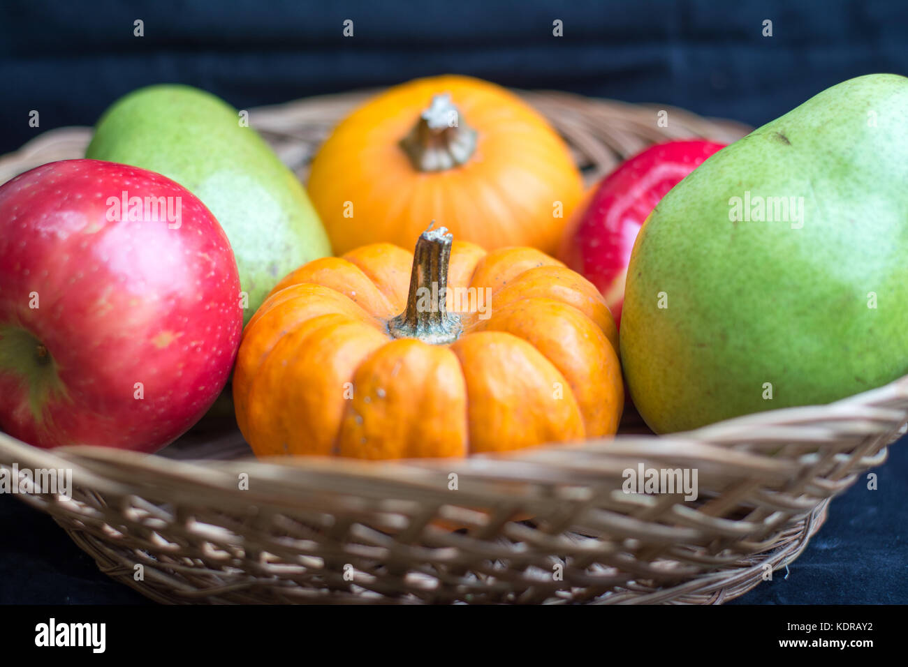 Herbst Ernte von Äpfeln, Birnen und Kürbisse in einem Weidenkorb. Stockfoto