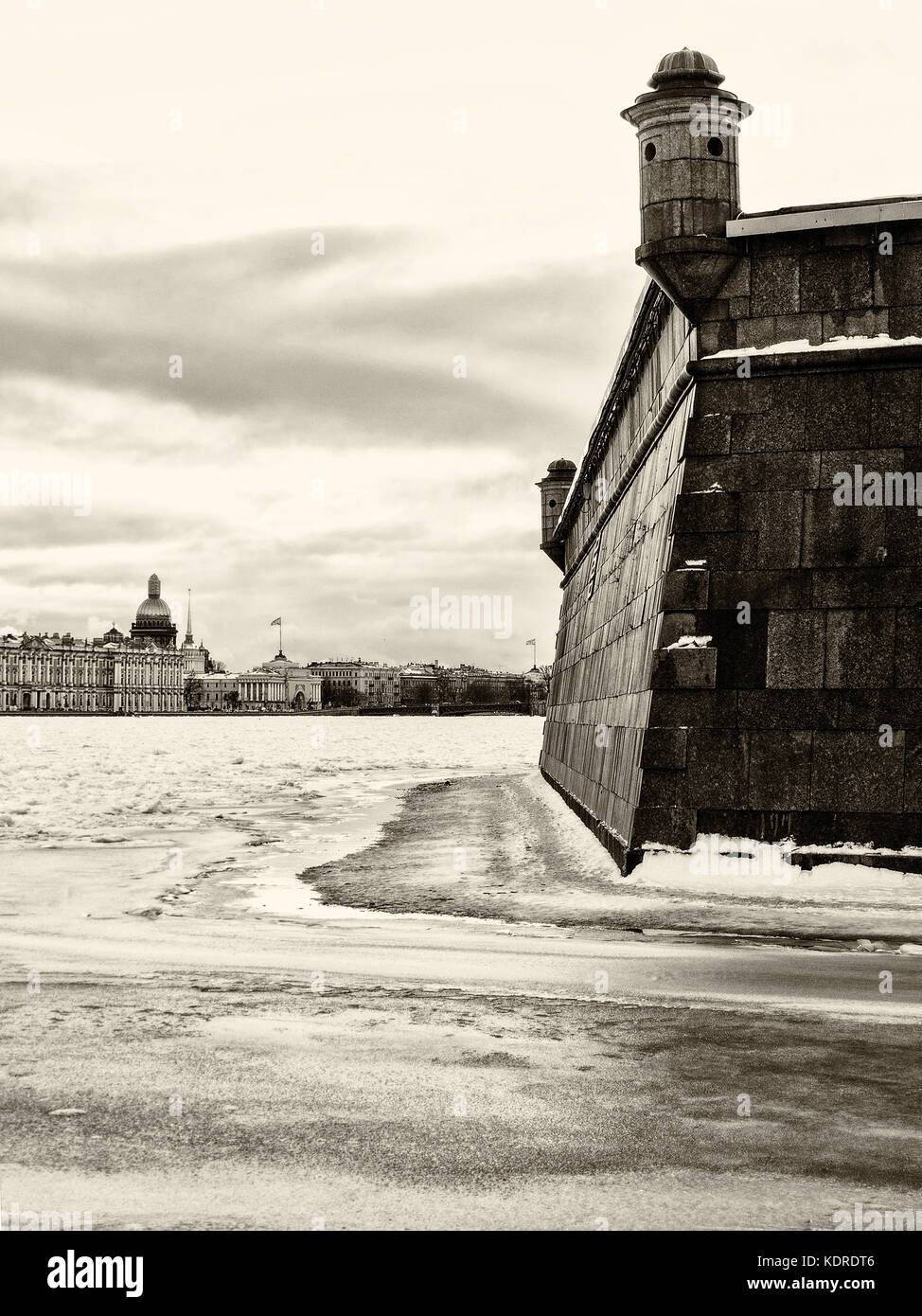 Sehenswürdigkeiten in St. Petersburg, Russland: Peter und Paul Festung Wand durch Wintertag, Newa in Eis, Himmel mit Wolken und historischen Zentrum der Stadt als Stockfoto