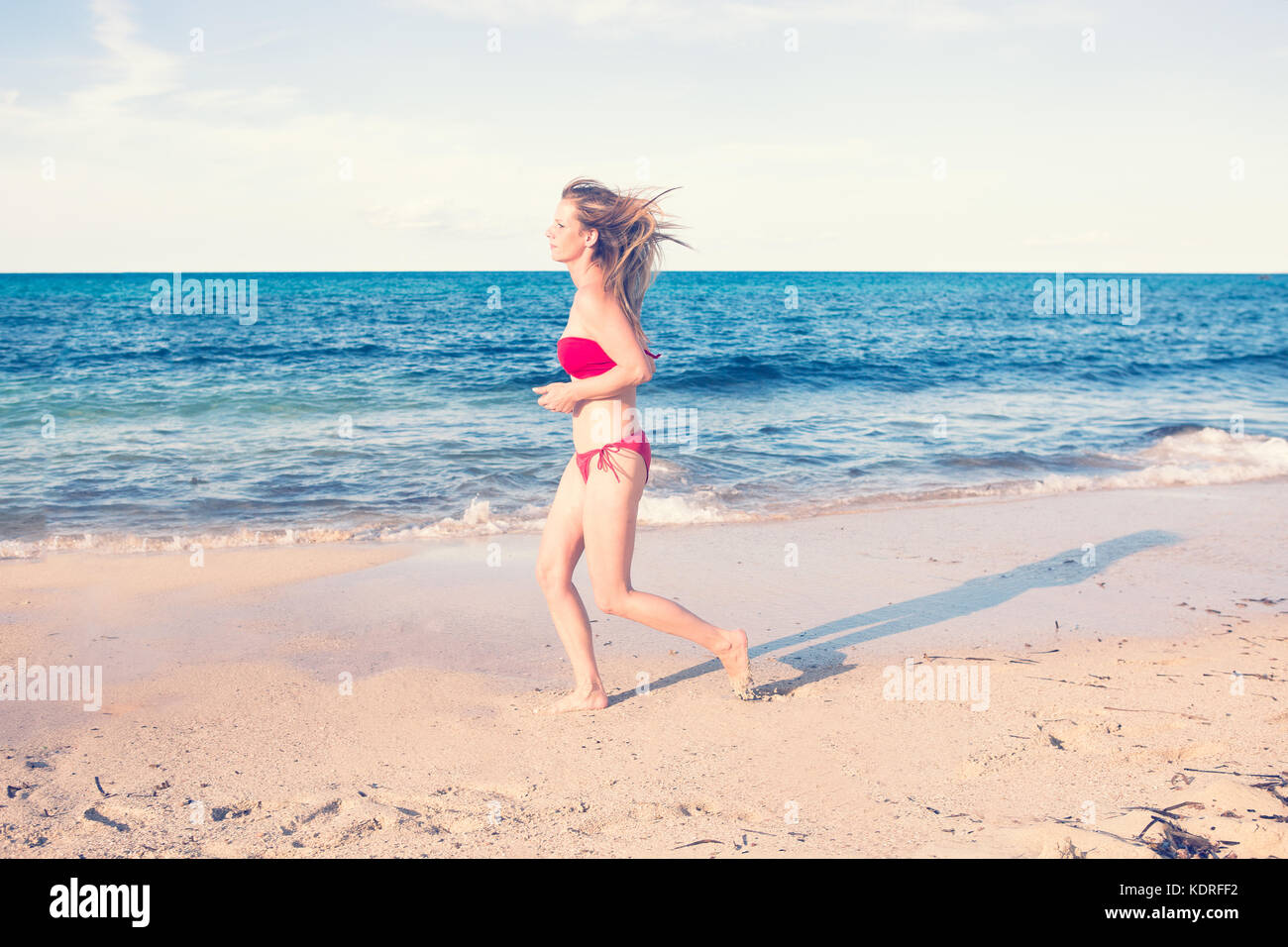Europa, Spanien, Balearen, Mallorca, Cala Mesuida - eine junge Frau beim Joggen am Strand Stockfoto