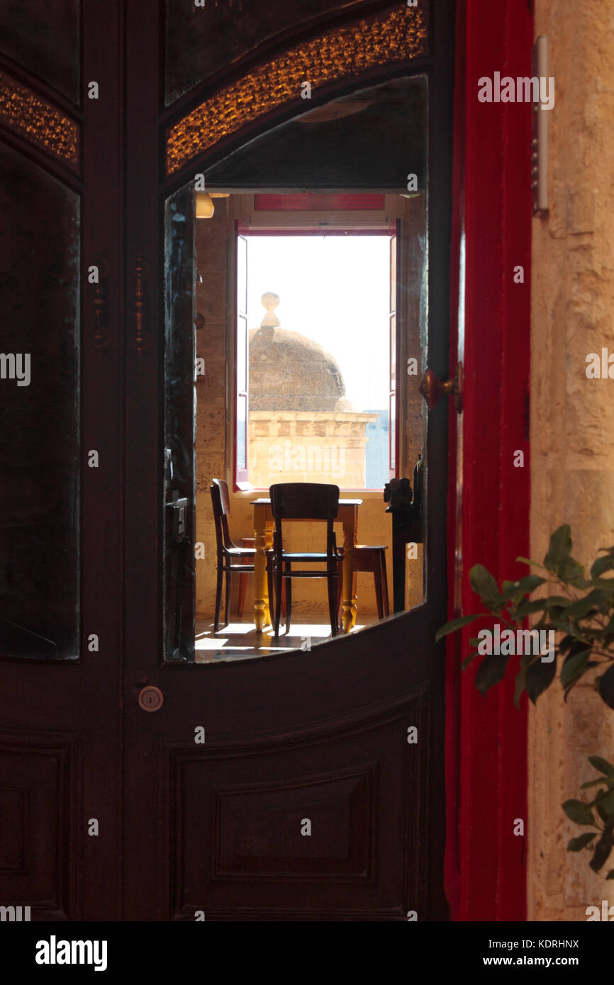 Blick durch die vorderen Türen eines Hotel in Valletta, Malta, mit einem vedette oder sentrybox auf die Befestigungsanlagen sichtbar aus einem Fenster auf der Rückseite Stockfoto