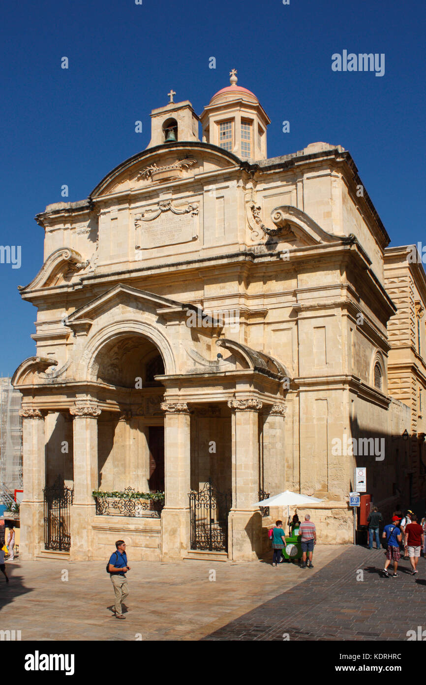 Valletta, Malta, Europa. Menschen, die an der Kirche der Heiligen Katharina von Alexandria (auch bekannt als Kirche der Heiligen Katharina von Italien) vorbeigehen. Stockfoto