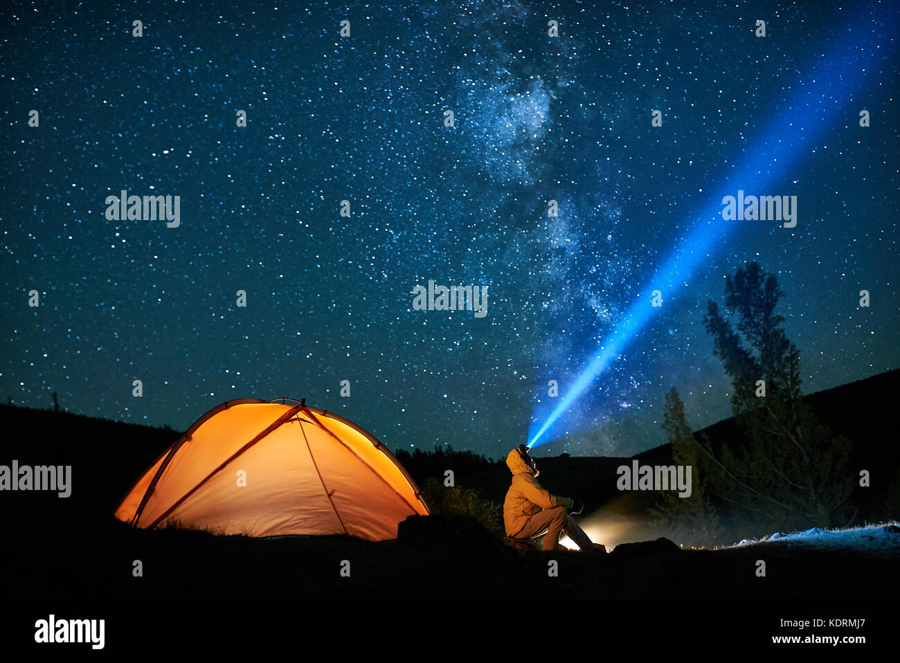 Man Touristen mit Taschenlampe in der Nähe seiner camp Zelt in der Nacht. Stockfoto