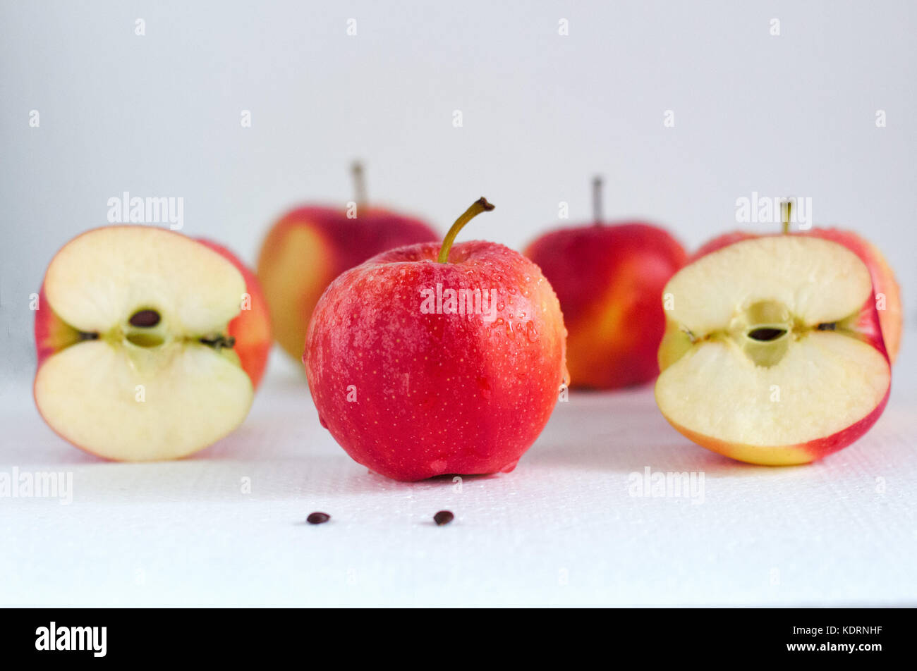 Reife rote Äpfel mit Tropfen Wasser auf weißem Hintergrund Nahaufnahme Stockfoto