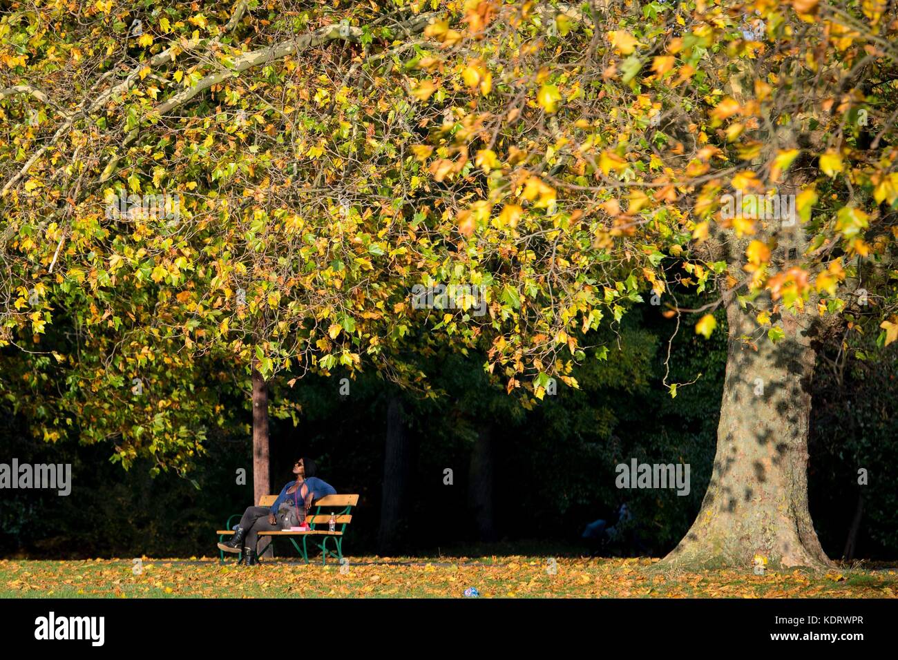 Eine Frau genießt das warme Wetter im Hilly Fields Park im Südosten Londons, da Teile Großbritanniens ein für die Jahreszeit unweigerlich warmes Wetter hatten, während sich der Orkane Ophelia dem Vereinigten Königreich und Irland nähert. Stockfoto