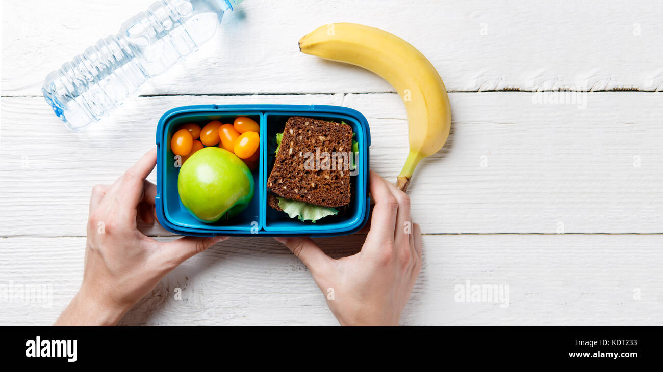 Foto der Hände des Menschen mit nützlichen Mittagessen in Feld Stockfoto