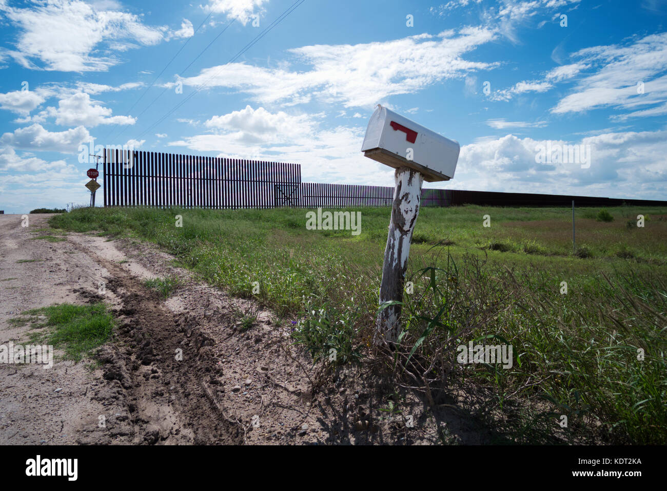 Texas Grenzzaun sitzt auf einem Deich, in der Nähe von Texas an der mexikanischen Grenze mit einem Bauern Mailbox in den Vordergrund. Dieser Teil des Zauns wurde während gebaut Stockfoto