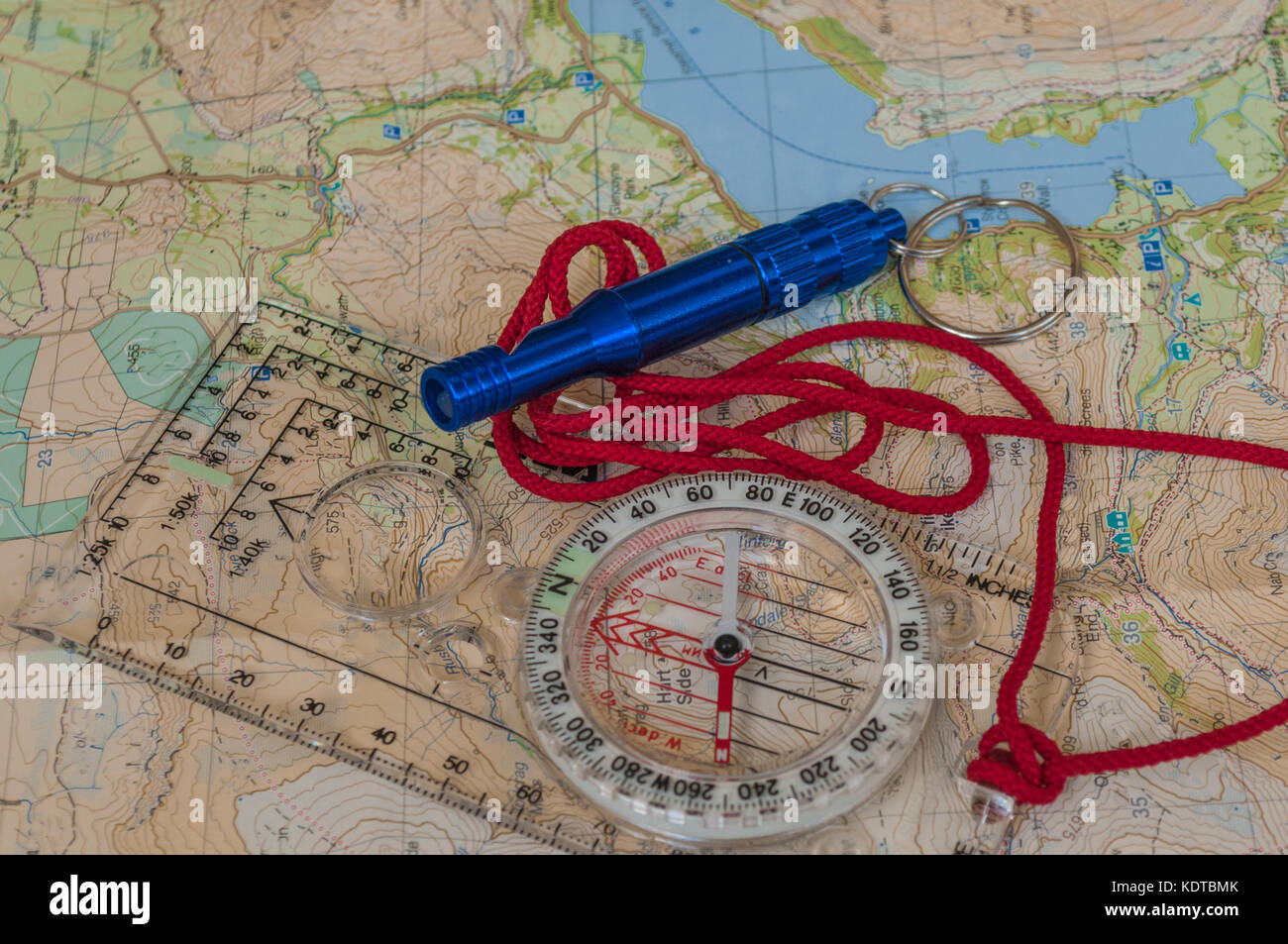 Kompass, der die Richtung auf topografische Karte mit rescue Pfeifen, Navigation, geringe Tiefenschärfe, Fokus auf Nord Stockfoto