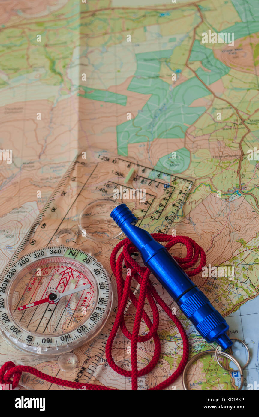 Kompass, der die Richtung auf topografische Karte mit rescue Pfeifen, Navigation, geringe Tiefenschärfe, Fokus auf Nord Stockfoto