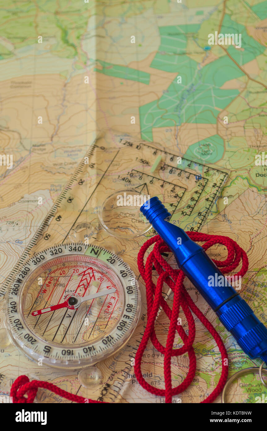 Kompass, der die Richtung auf topografische Karte mit rescue Pfeifen, Navigation, geringe Tiefenschärfe, Fokus auf Nord Stockfoto