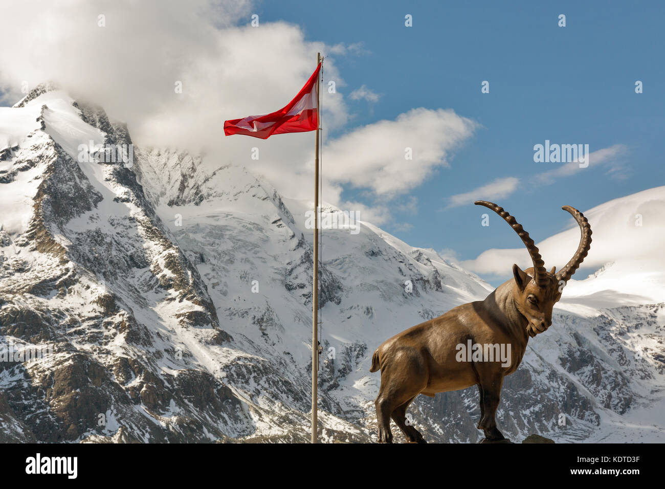 Alpensteinbock Statue und die österreichische Fahne an der Spitze des Berges an der Großglockner Hochalpenstraße Bereich in Österreich. Stockfoto