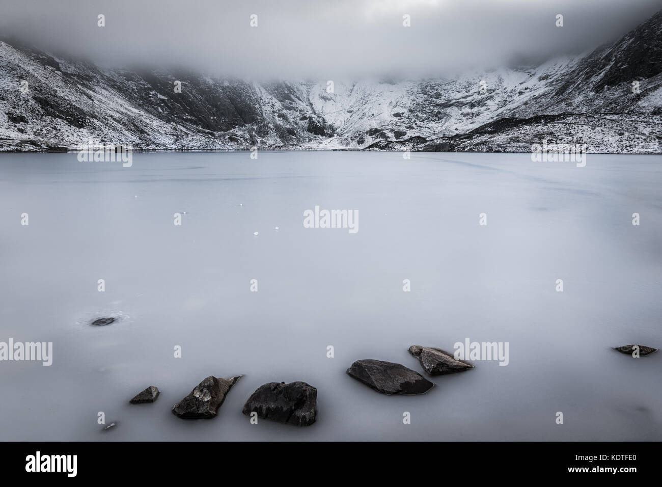 Llyn Idwal mit gefrorenen See und niedrige Nebel im Winter, Ogwen, Wales, UK gebildet Stockfoto