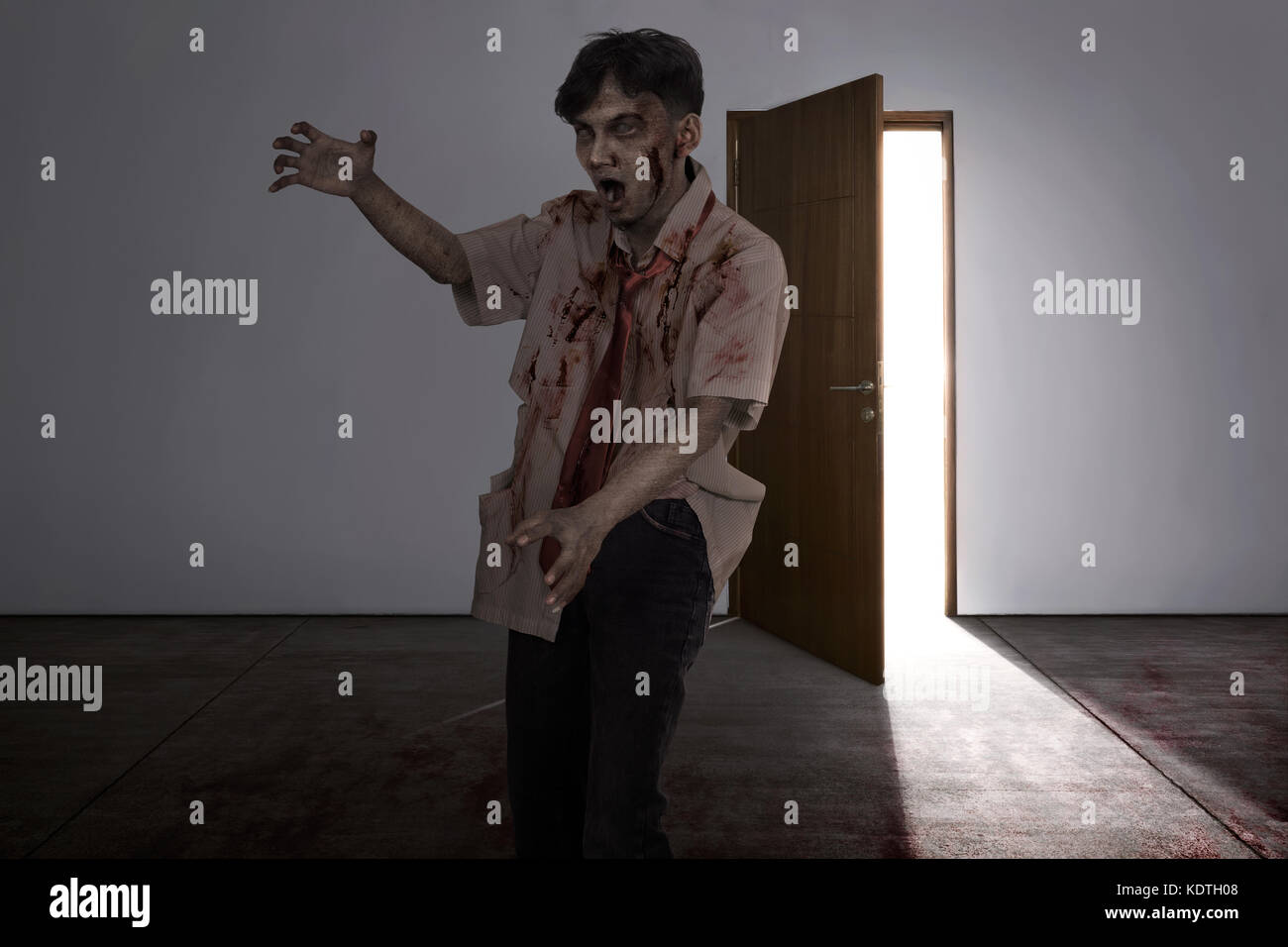 Aggressive asiatische zombie Mann mit verwundeten Gesicht in die dunklen Zimmer Stockfoto
