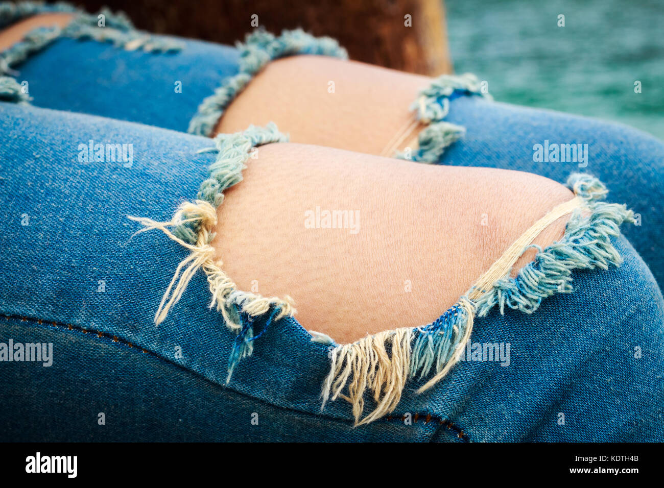 Jeans mit zwei große Löcher und Bits von Gewinde in die Knie  Stockfotografie - Alamy