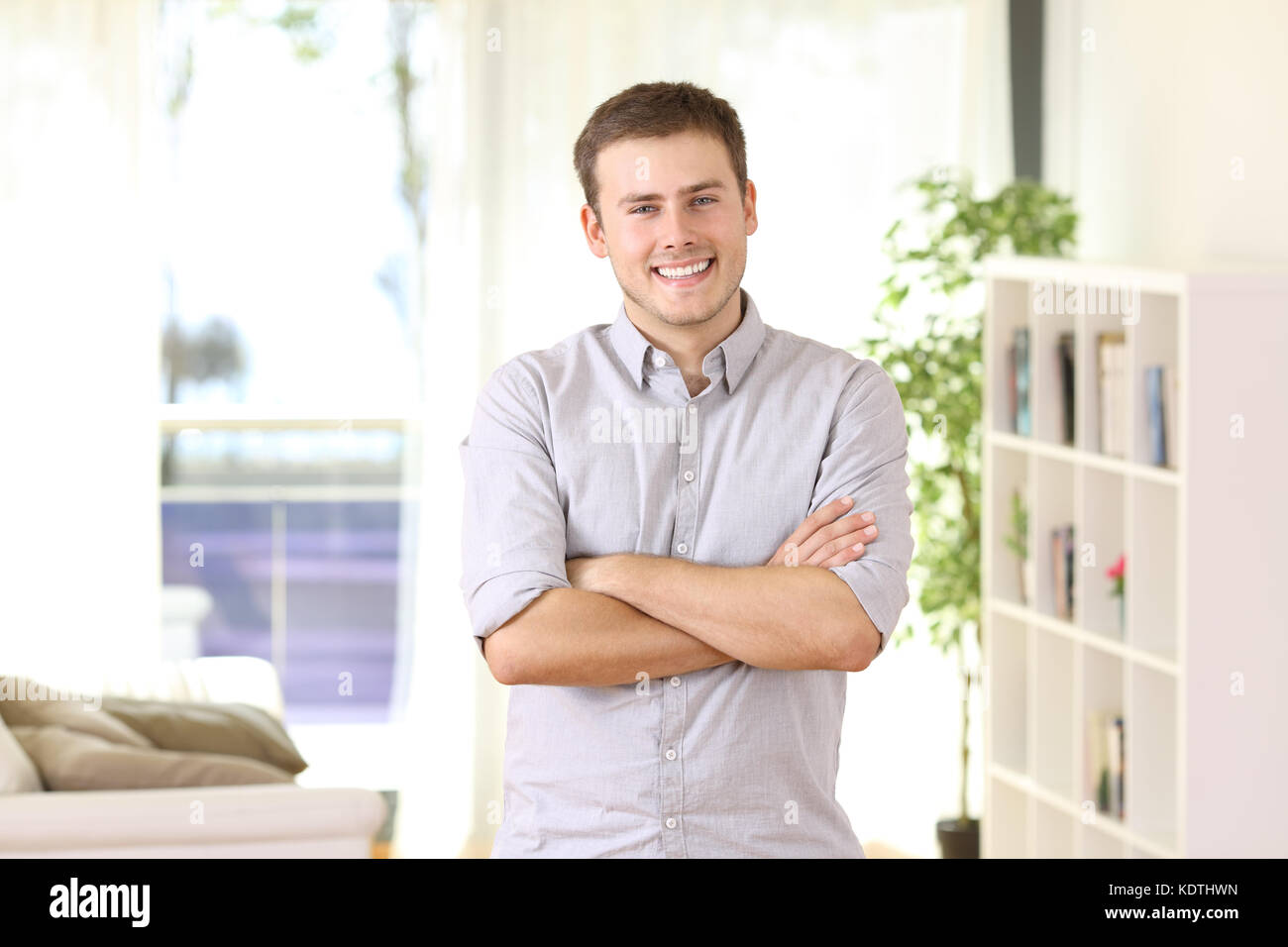 Glückliche Eigenheimbesitzer portrait stehend zu Hause mit Möbel und Fenster im Hintergrund posiert Stockfoto