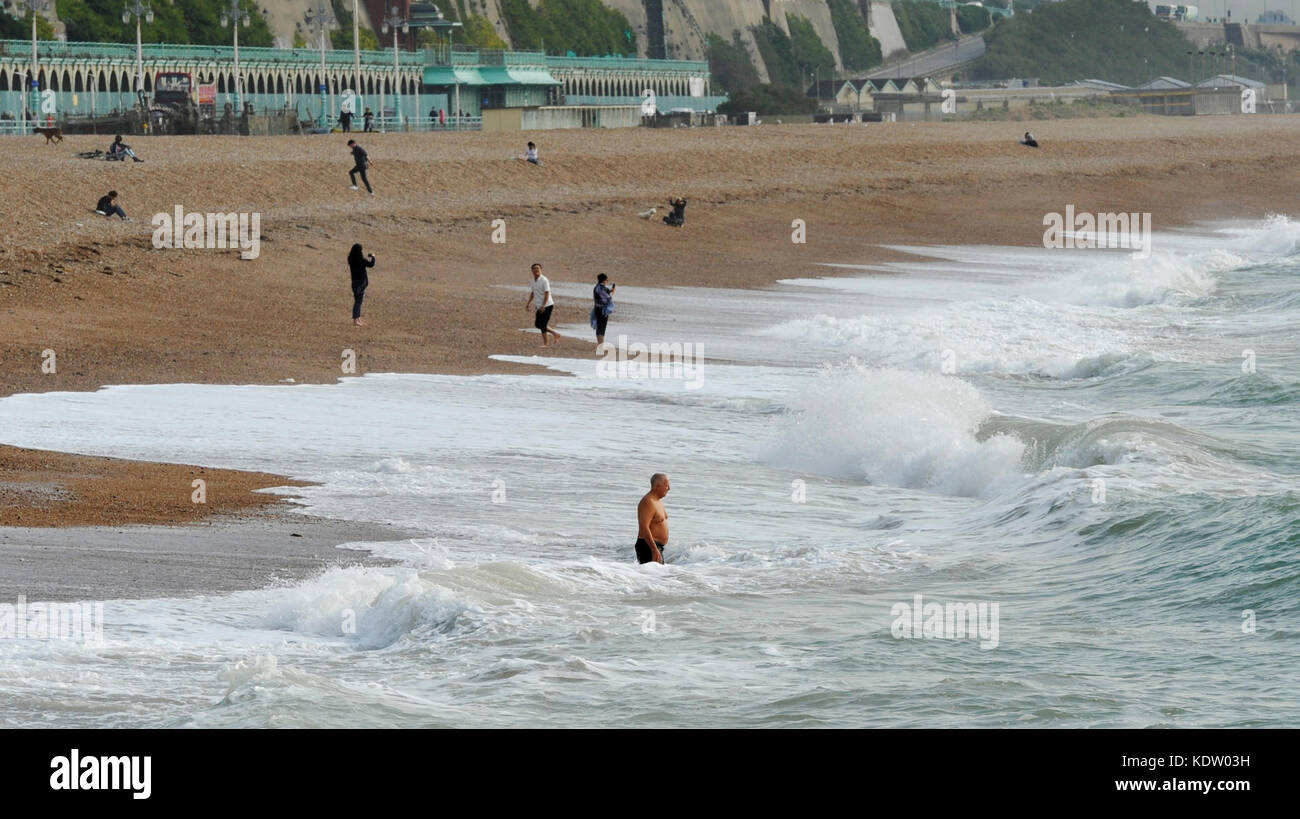 Brighton, uk. 16 Okt, 2017. de Wetter ein Schwimmer Köpfe in das Meer aus Brighton Beach einen ungewöhnlich warmen und sonnigen Herbsttag mit Temperaturen über 20 Grad. In der Zwischenzeit Irland und der Westküste von Großbritannien stützen sich auf die Ankunft der Schwanz Ende der Hurrikan Ophelia 30 Jahre nach dem großen stortm 1987: Simon dack/alamy leben Nachrichten Stockfoto