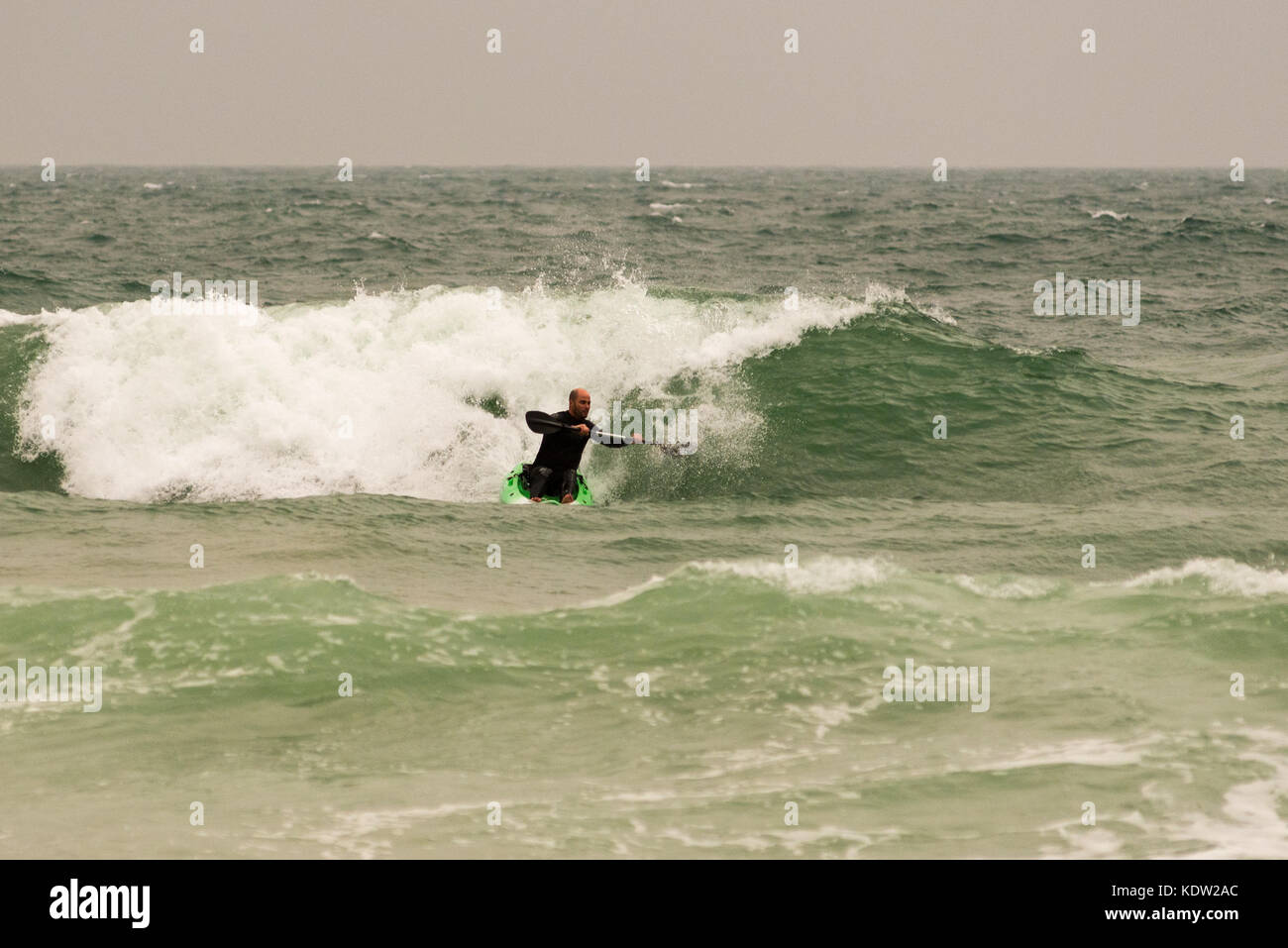 Wassersport Enthusiasten paddeln, Meer in großen Wellen und starke Winde von Sturm, ex - Hurrikan Ophelia in Boscombe, Bournemouth, Dorset, Großbritannien, Oktober 2017. Stockfoto