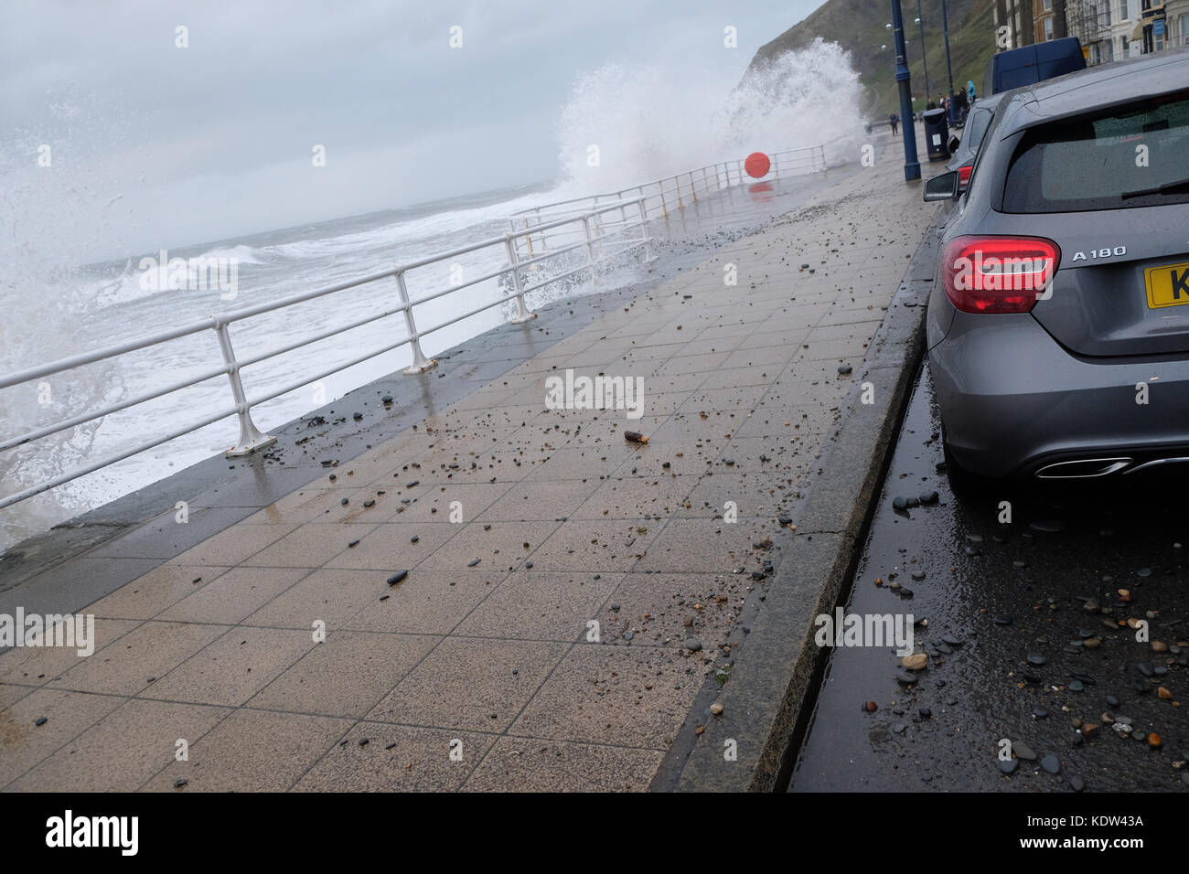 Aberystwyth, Ceredigion, Wales, UK-Flut kommt mit Sturm Ophelia offshore über die Irische See - Peebles und Kies auf der Promenade geworfen Hit geparkten Autos-stong Winde in Aberystwyth auf der West Wales Küste als Sturm Ophelia Ansätze aus der Irischen See mit lokalen Winden von mehr als 50 km/h. Foto Steven Mai/Alamy leben Nachrichten Stockfoto