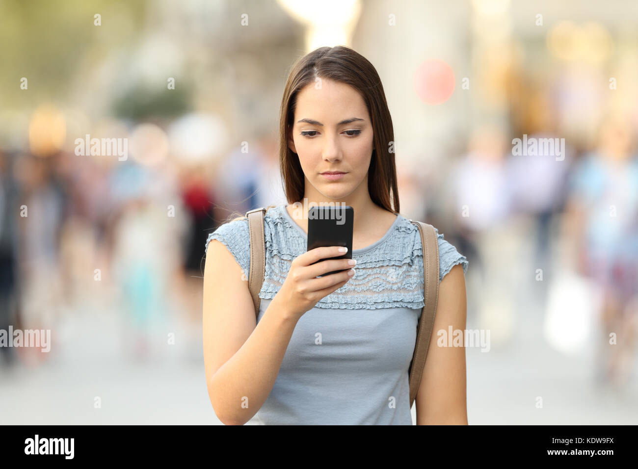 Vorderansicht eines schweren Mädchen Kontrolle eine telefonische Nachricht zu Fuß auf der Straße Stockfoto