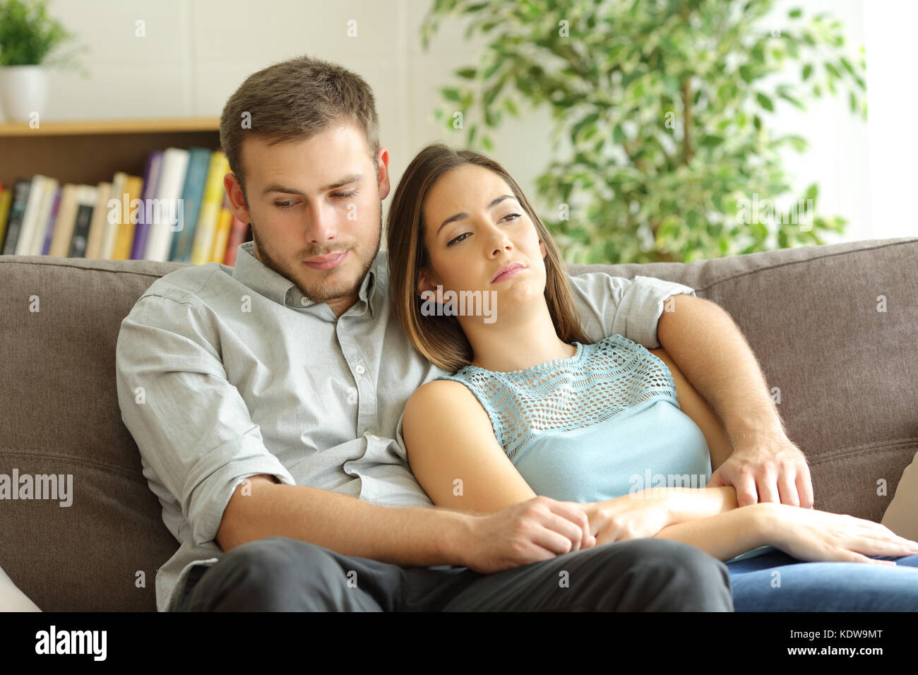 Gelangweilt einige Zeit auf einem Sofa zu Hause sitzen Stockfoto