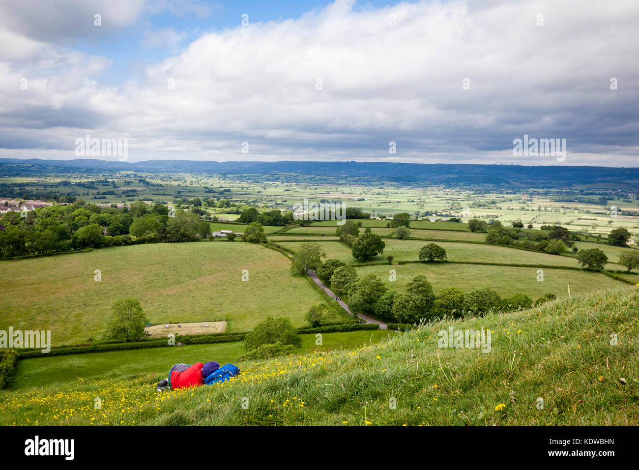 Anonyme Person schlafen auf den Pisten von Glastonbury Tor mit schönen Landschaft von Somerset als Hintergrund. Stockfoto