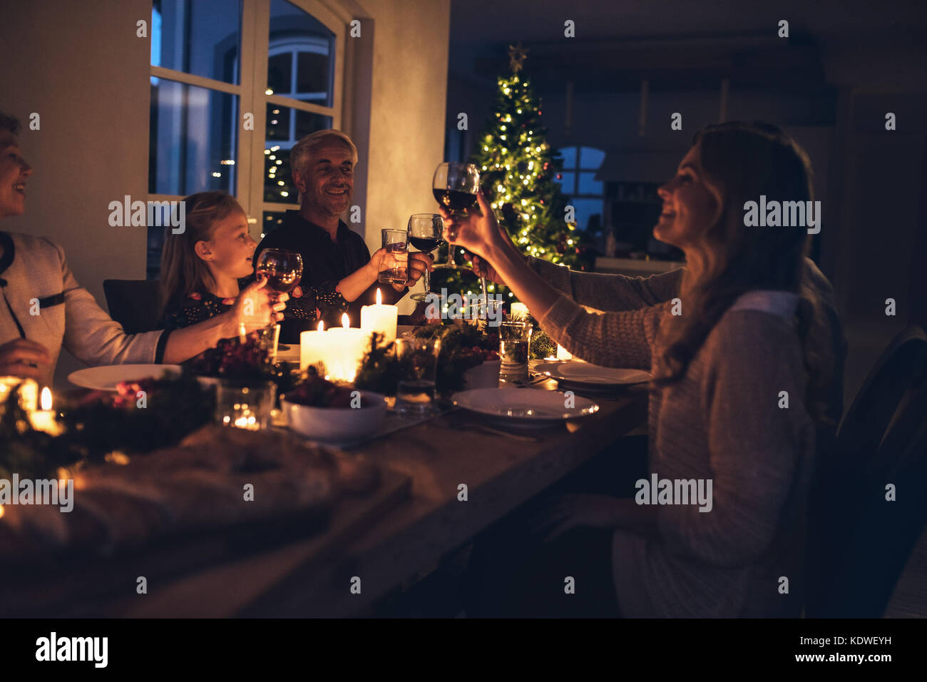 Happy Family toasten Weingläser am Esstisch im Haus. Familie am Esstisch für das Weihnachtsessen im Haus. Stockfoto