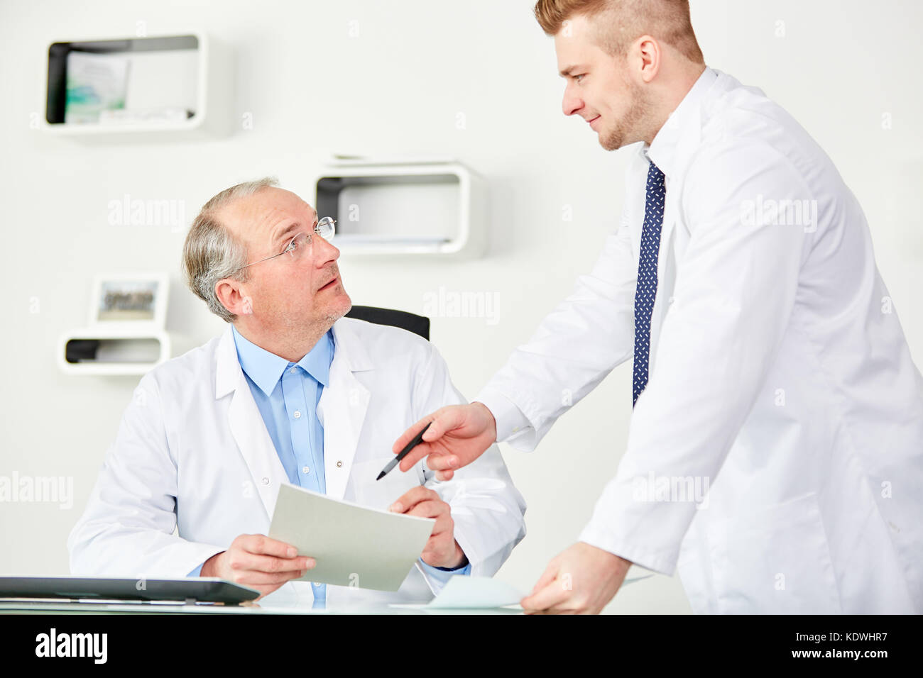 Leitender Arzt als Arzt im Teamwork Patientenakte diskutieren Stockfoto