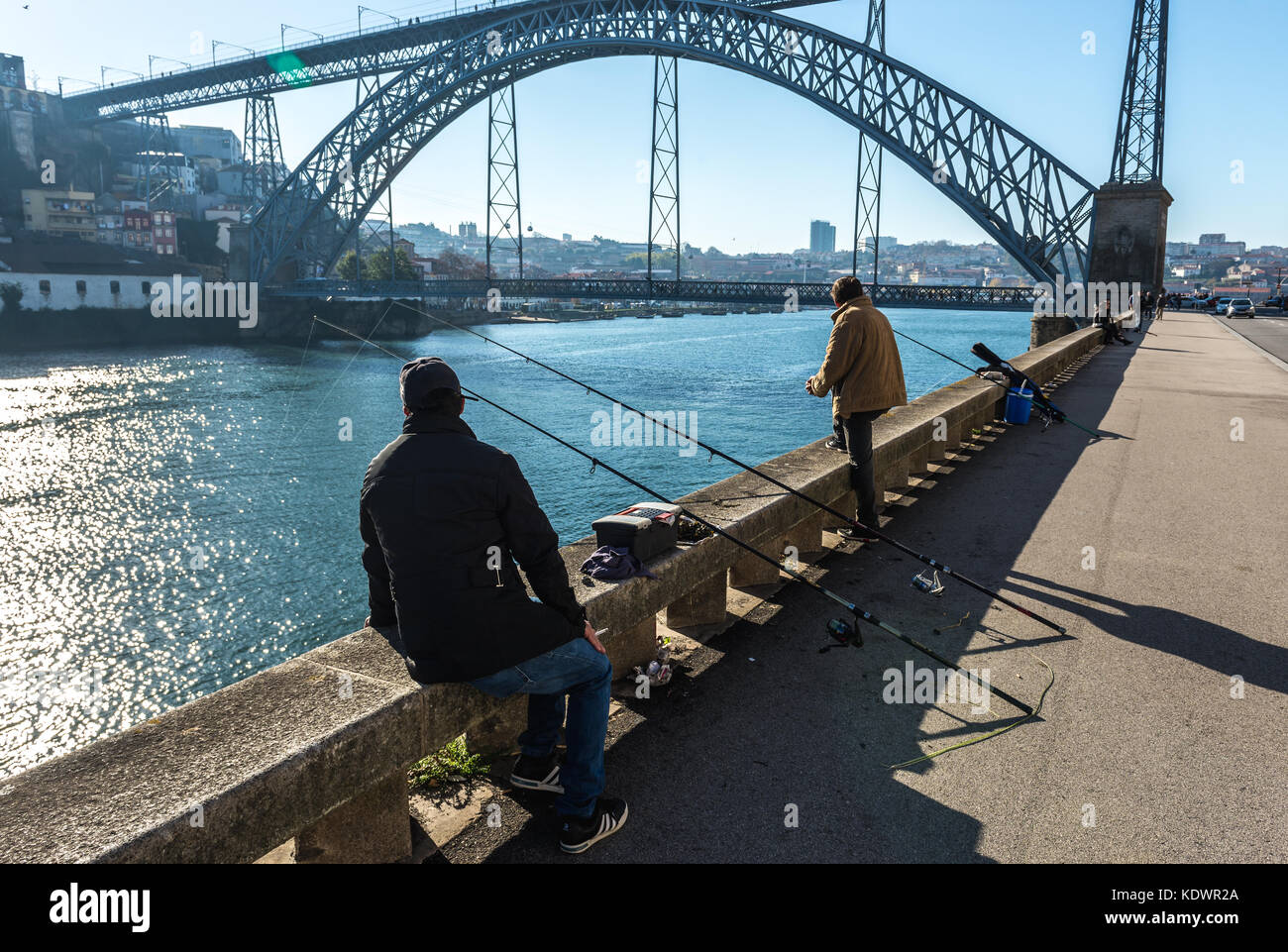 Männer Angeln im Douro Fluss in Porto Stadt, Portugal. Dom Luis I Brücke zwischen den Städten Vila Nova de Gaia (links) und Porto im Hintergrund Stockfoto