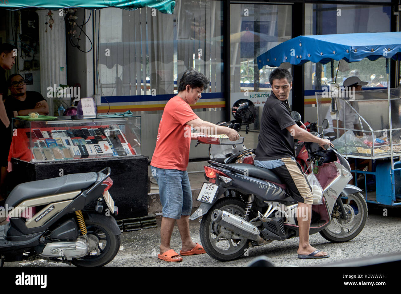 Lebensmittel-lieferservice. Männer Lieferung von Nahrung auf einem Motorrad. Thailand Südostasien Stockfoto