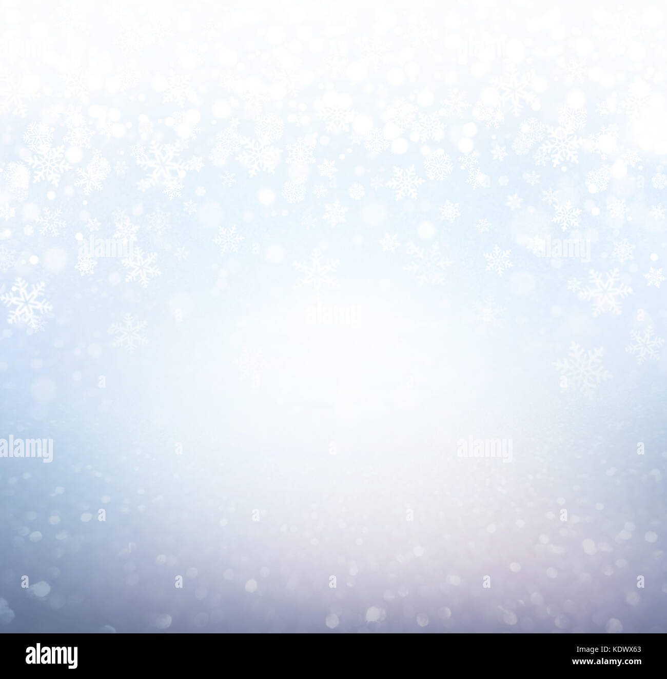 Schneeflocken und Schneefall auf einem eisigen blauen Hintergrund - Winter Material Stockfoto