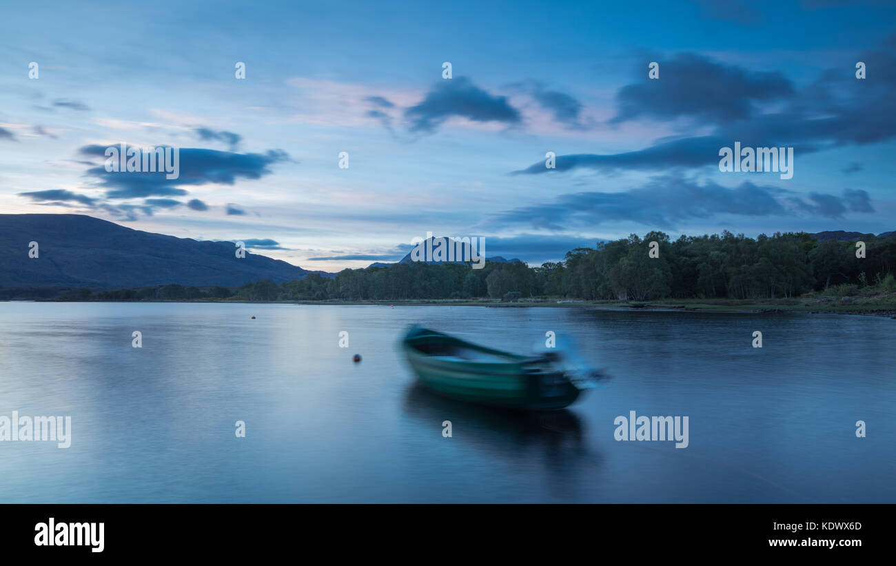 Breaking Dawn über ein Boot vertäut am Loch Maree, mit Slioch jenseits, Wester Ross, Schottland Stockfoto