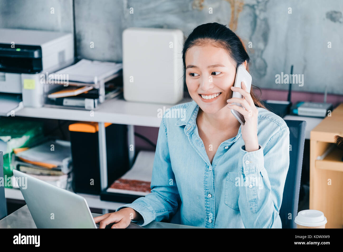 Asiatische kreative Designer Kontakt Kunden an mobile pone mit lächelnden Gesicht, starten Eigentümer unternehmen Konzept. Stockfoto