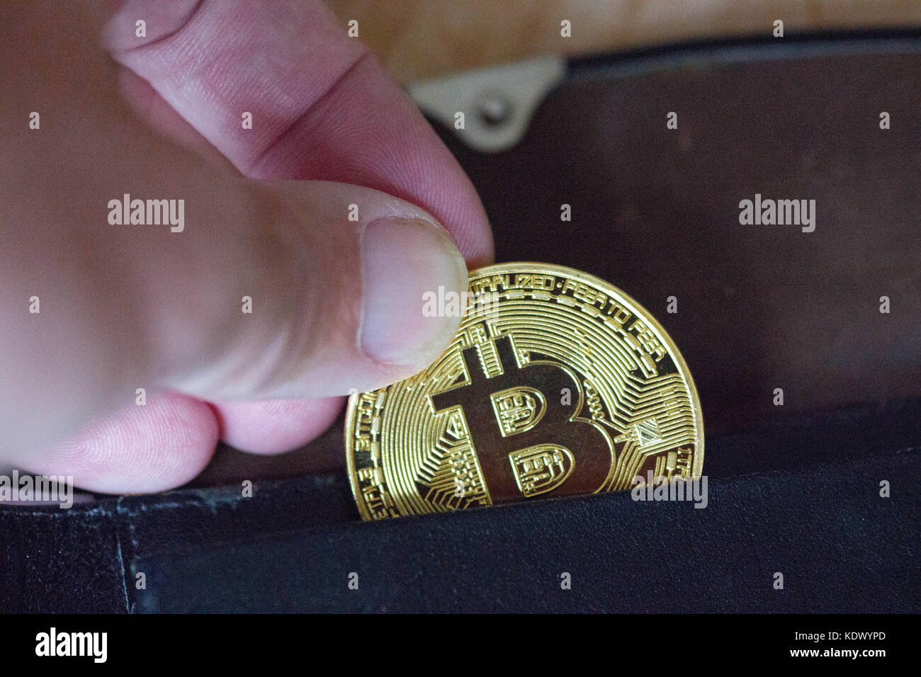 Bitcoin wird in die Brieftasche gesteckt Stockfoto