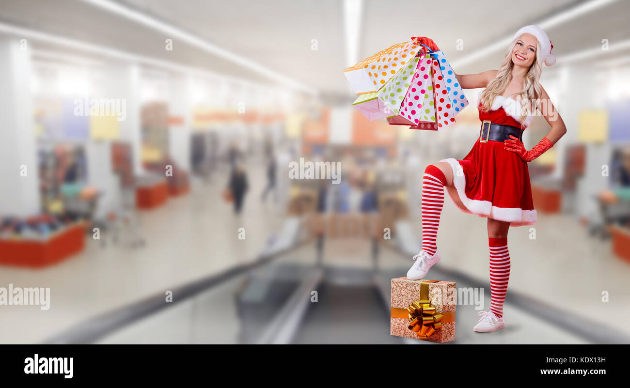 Ein Mädchen in santa claus Kostüm mit einem Paket von Geschenken auf dem Bac Stockfoto