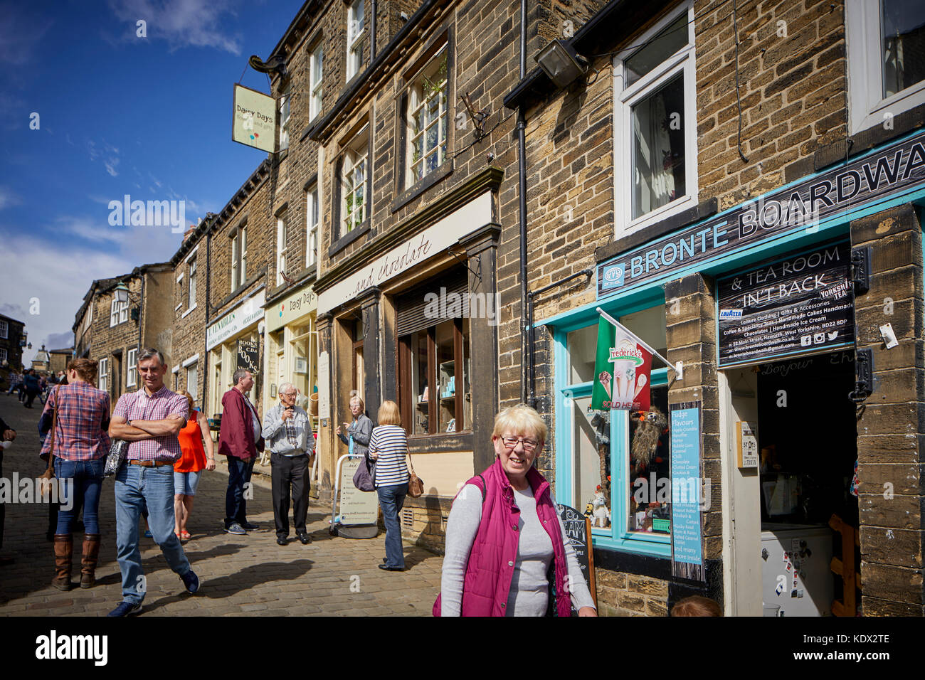 Pennines Dorf, Haworth in West Yorkshire, England. terrassierten Häuser und Geschäfte auf der steilen Straße Stockfoto