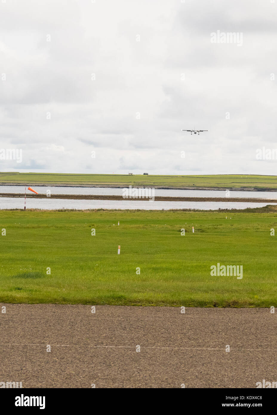Loganair-Flugzeug, das vom Flughafen Papa Westray am Horizont, Orkney-Inseln, Schottland, Großbritannien, in Richtung Westray Flughafen fliegt Stockfoto
