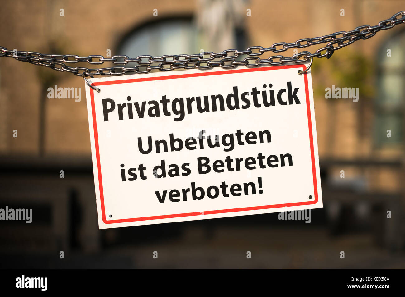 Warnschild mit deutschem Text 'Privatgrundstück - unbefugten ist das Betreten verboten' Stockfoto