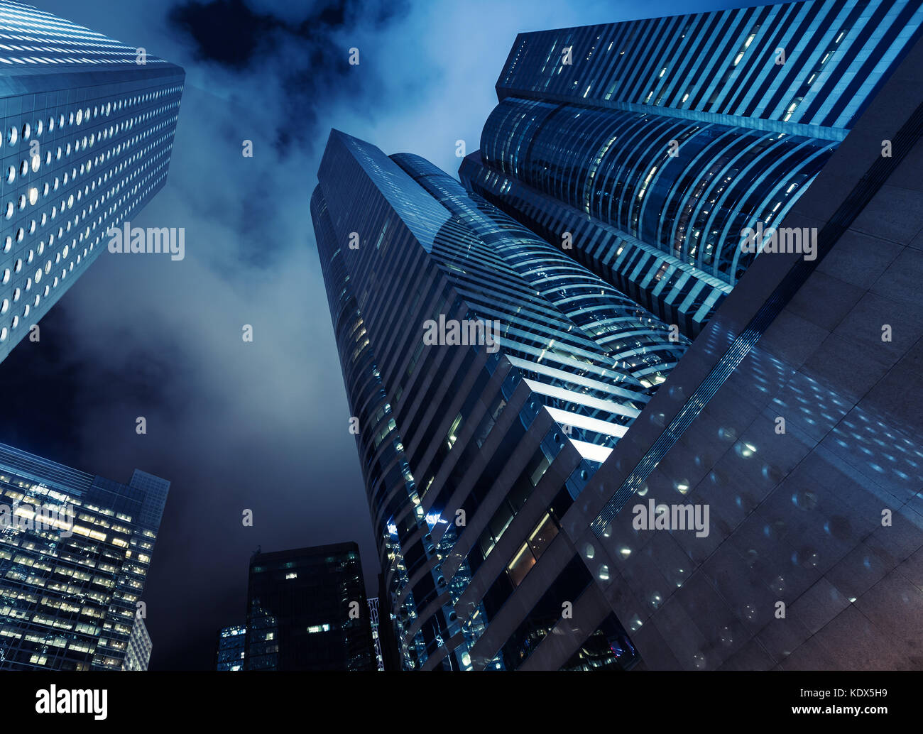 Wolkenkratzer unter dunklen Nachthimmel, hohes Bürogebäude in Hong Kong City. blau getönten Foto Stockfoto