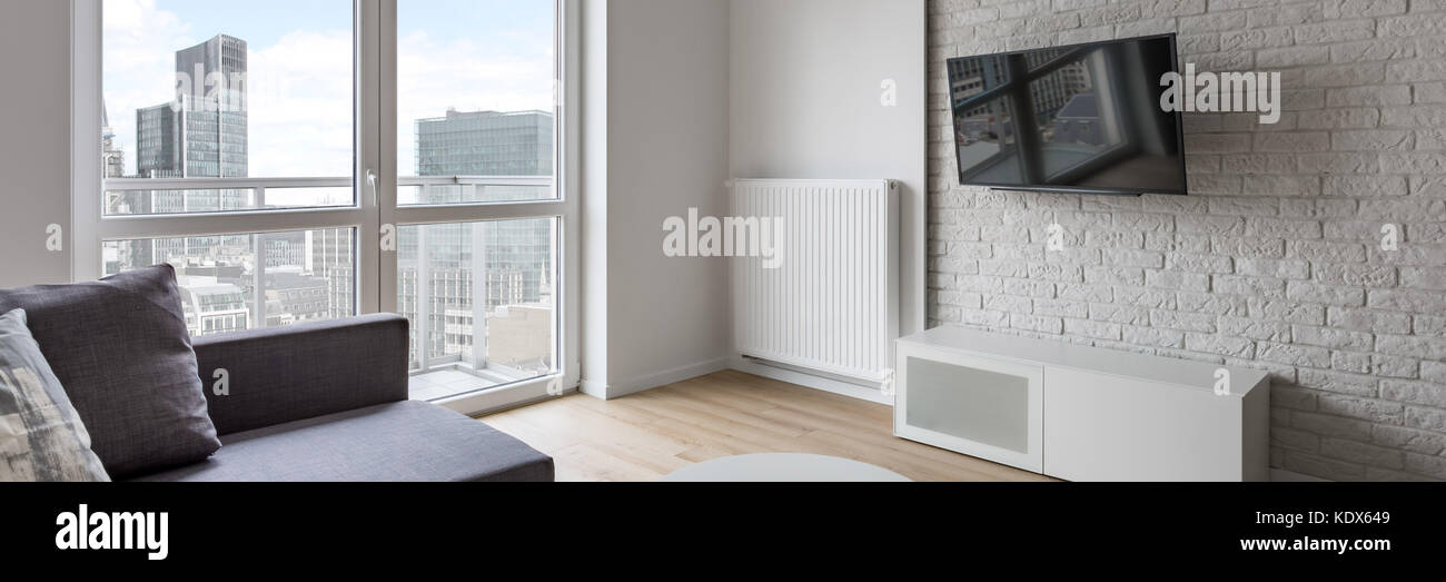Modernes Wohnzimmer mit TV, Couch, Mauer und Balkon, Panorama Stockfoto